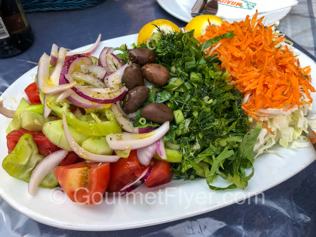A Greek salad with lots of veggie served on a large platter.