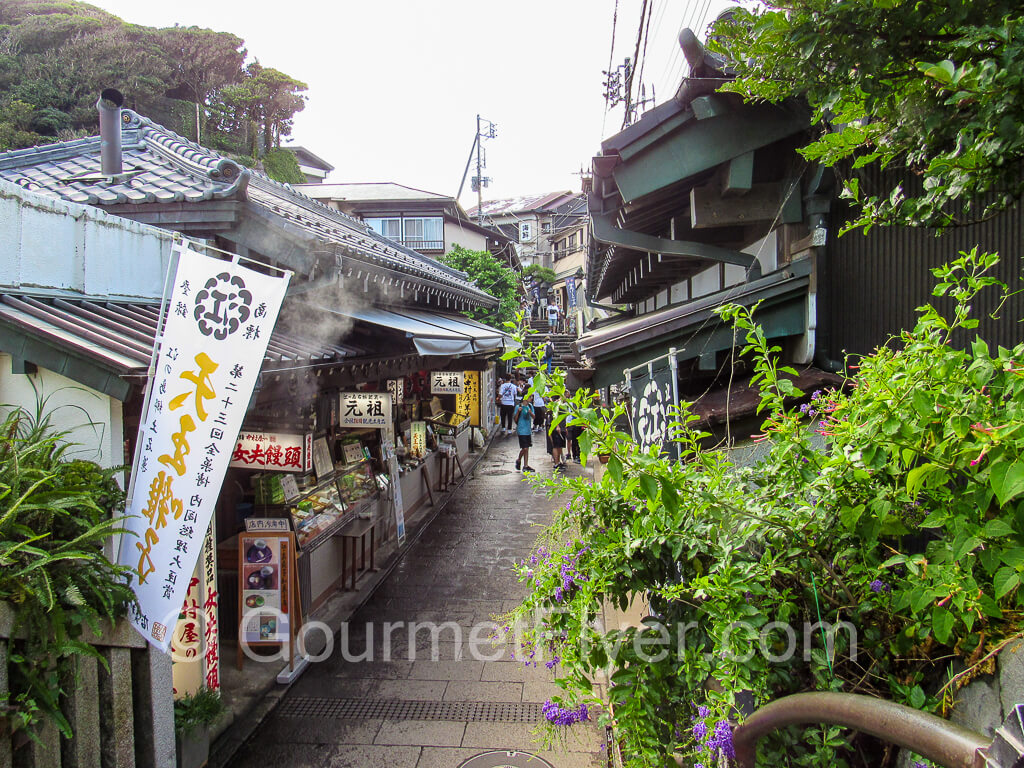 A quaint street with small traditional restaurants lining both sides of the street.