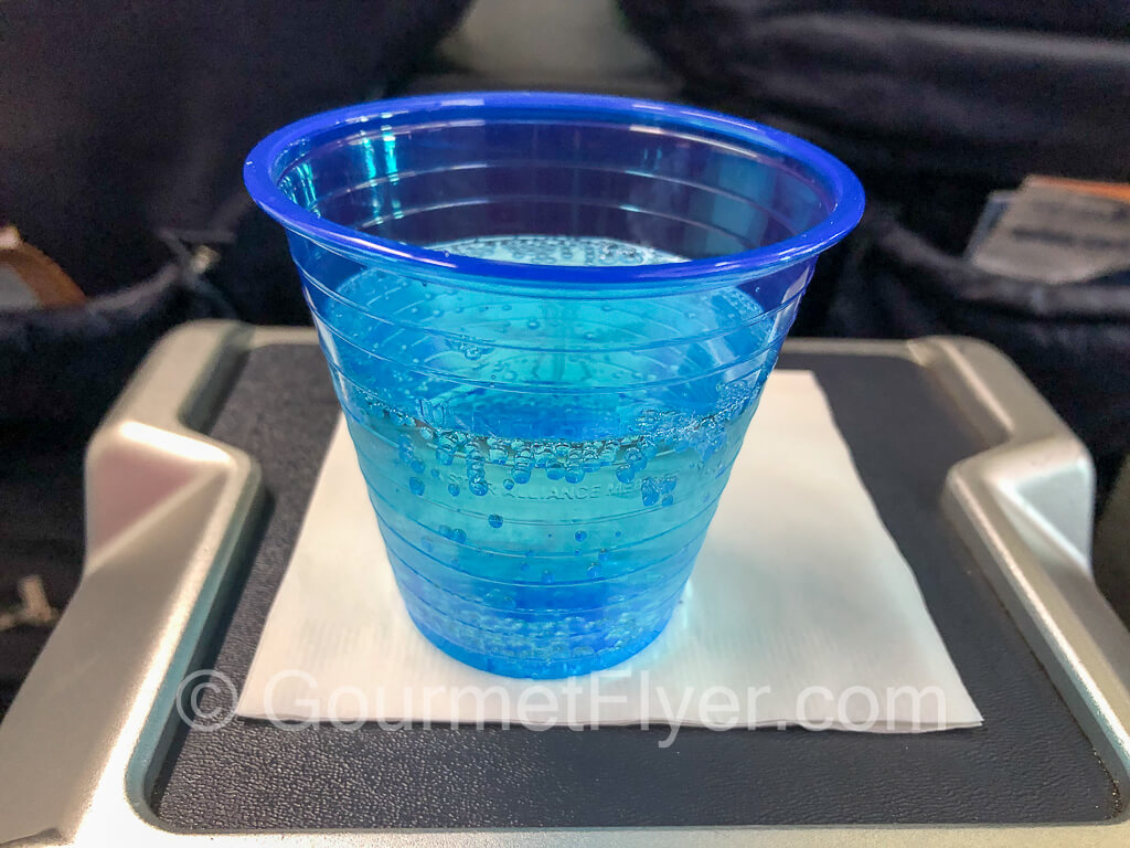 Sparkling wine in a blue plastic cup.