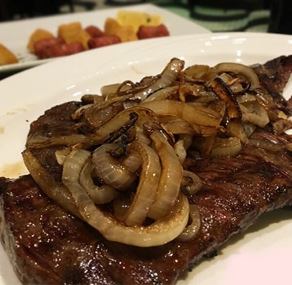 Churrasco steak topped with grilled onions.