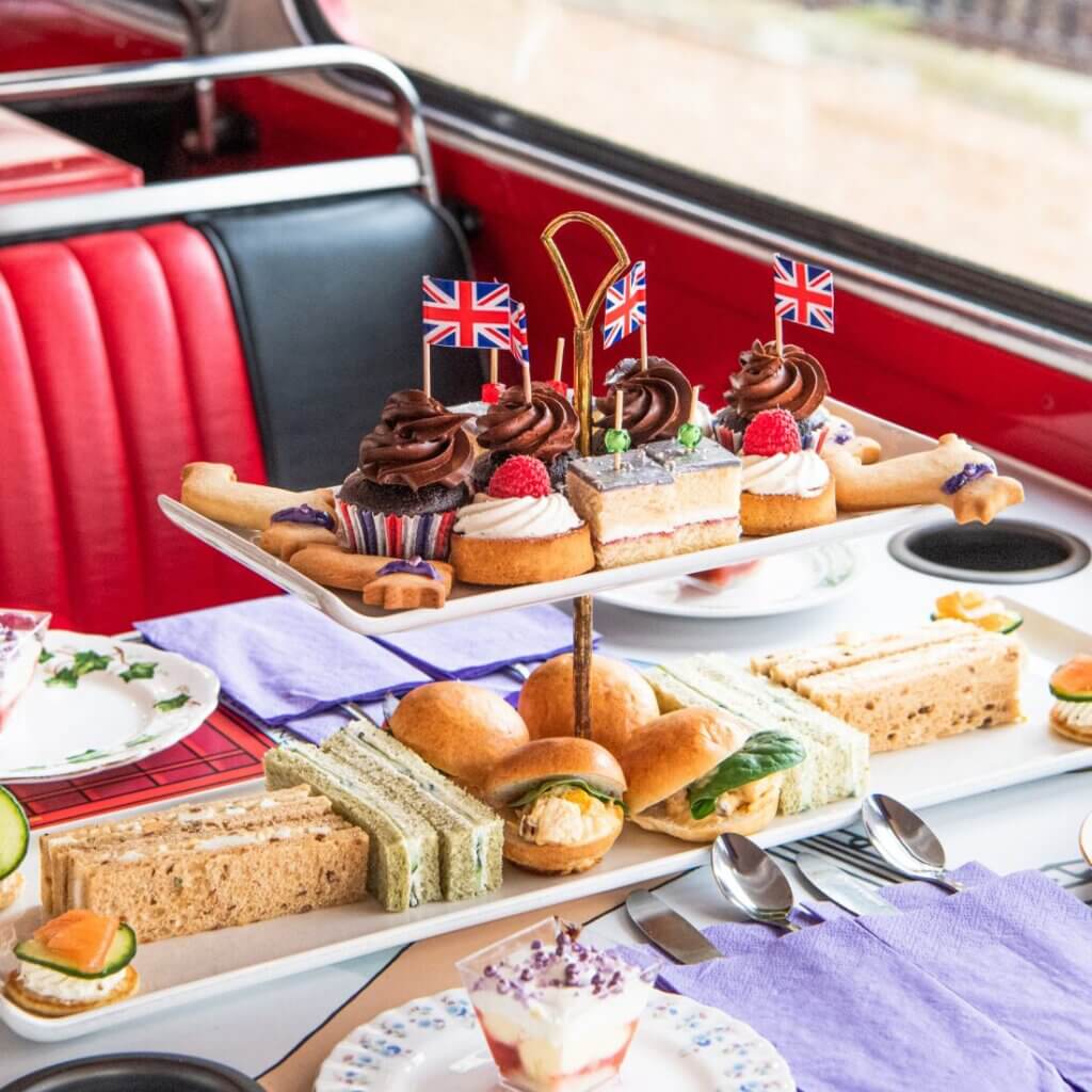 An afternoon tea set with finger sandwiches and bakeries served inside the bus.