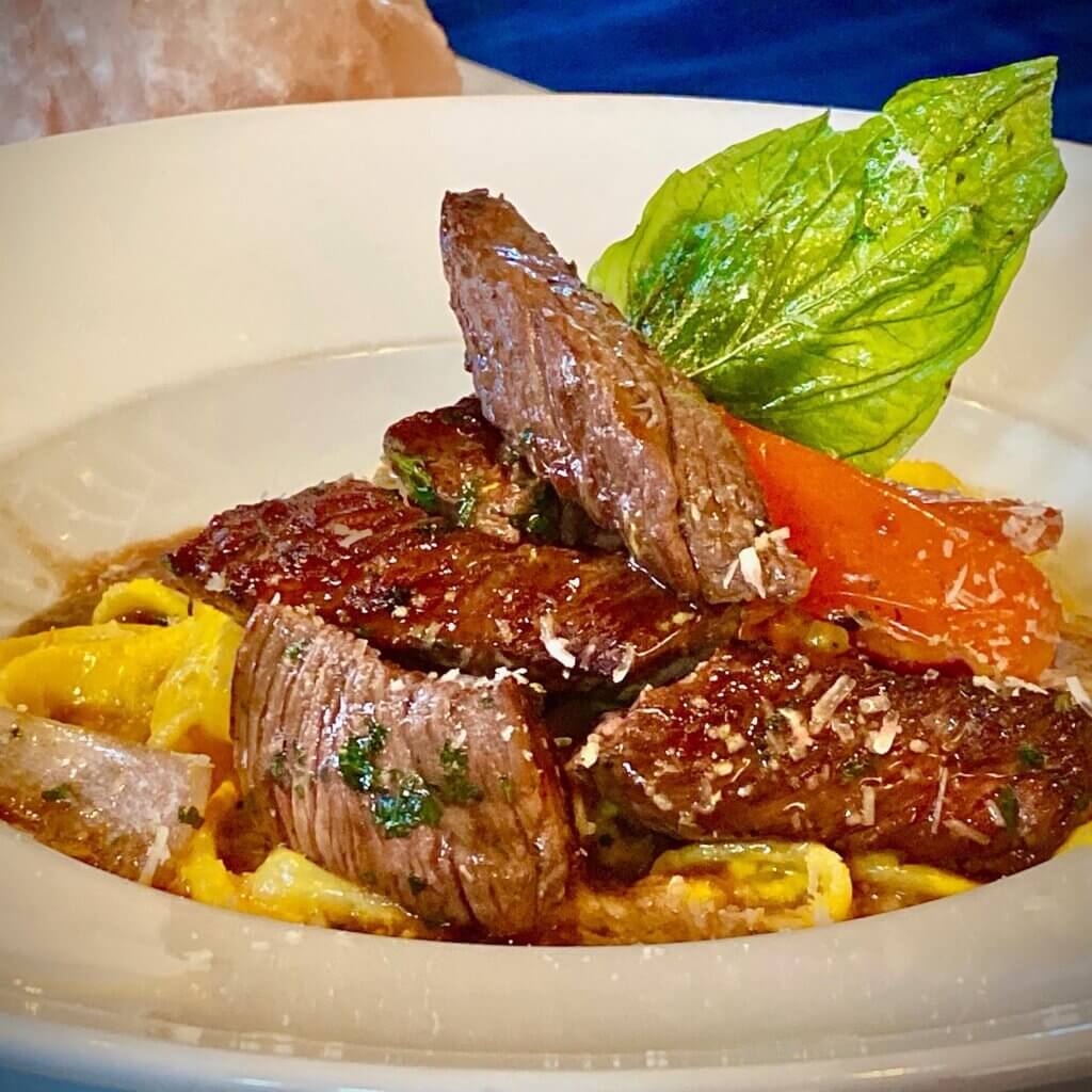 Peruvian pesto risotto topped with a tenderloin steak.