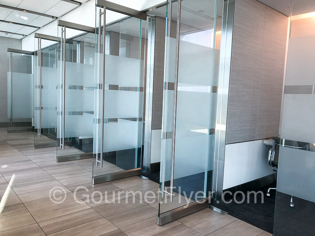 A bank of 5 phone booths with their doors opened.