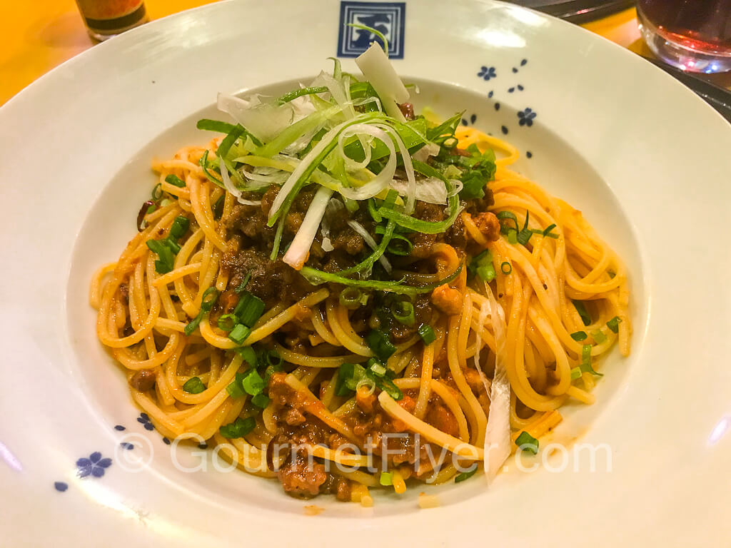 Spaghetti Bolognese garnished with plenty of green onions.