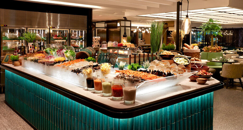 An enormous salad bar with salads, seafoods, and tubs of dressings.