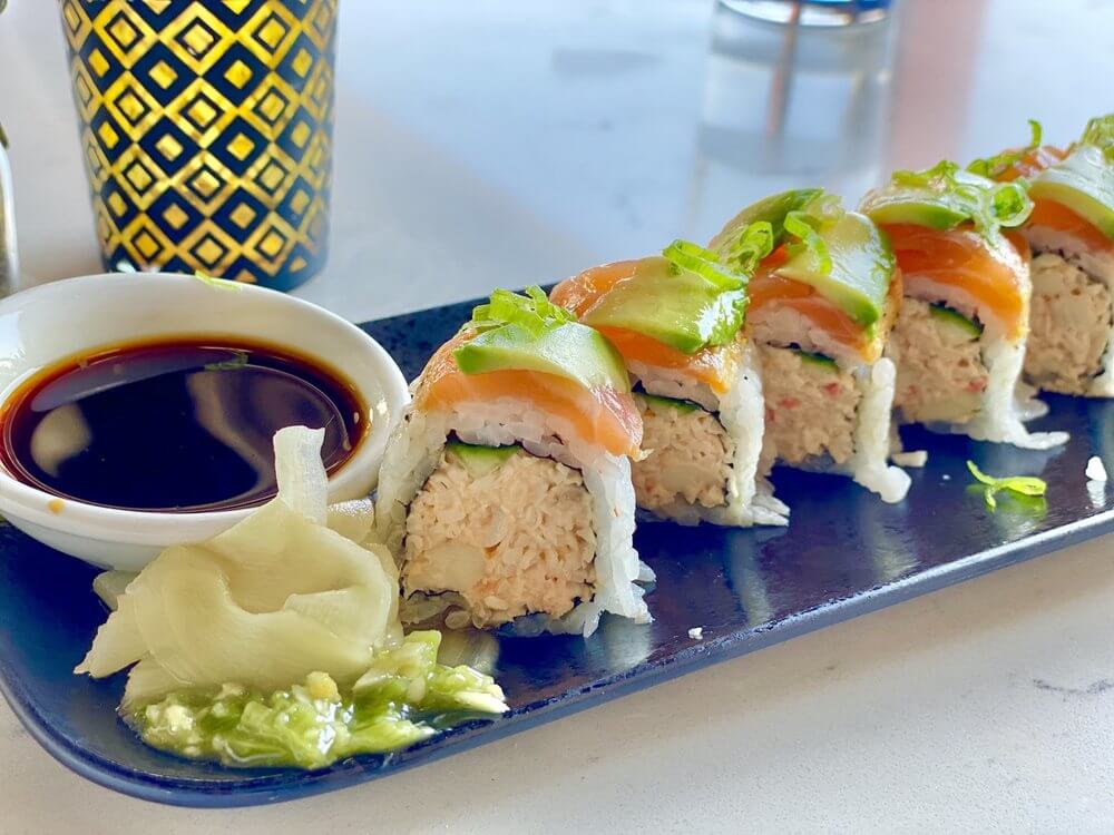 A platter of Lido sushi roll served with soy sauce, wasabi, and ginger.