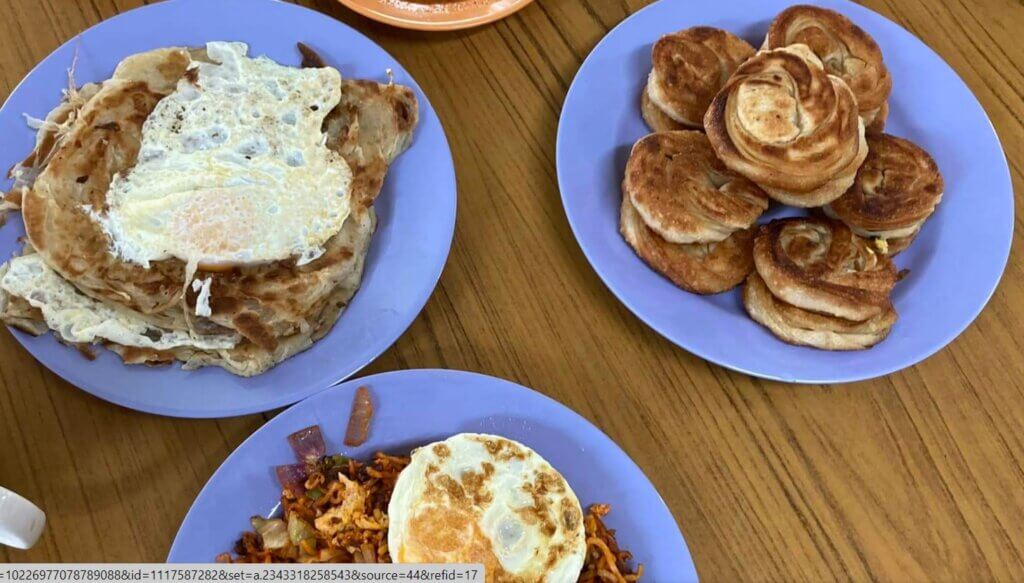 Roti prate topped with a fried egg on the left, and a plate of coin prata on the right.