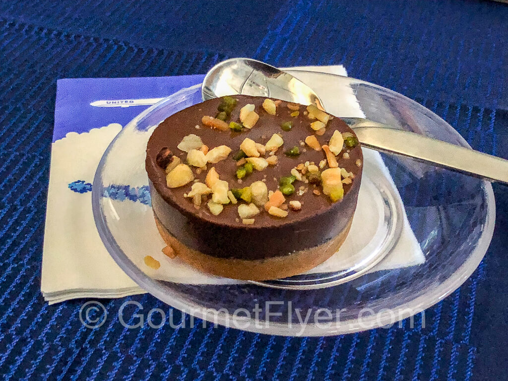 A round piece of individual chocolate cake on a plate.