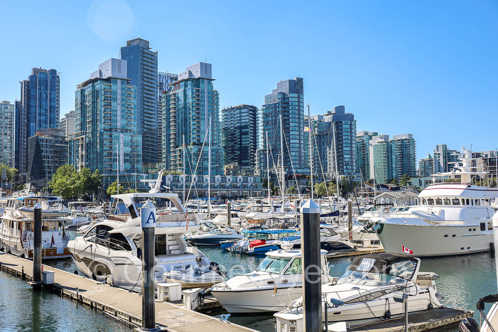 Yachts parked at the Coal Harbor Marina with Vancouver's skyline in the backdrop.