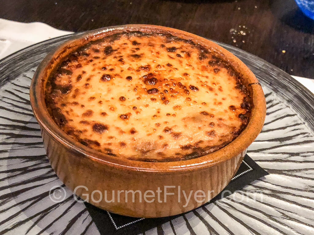 Traditional moussaka baked in a bowl with a golden-brown top.