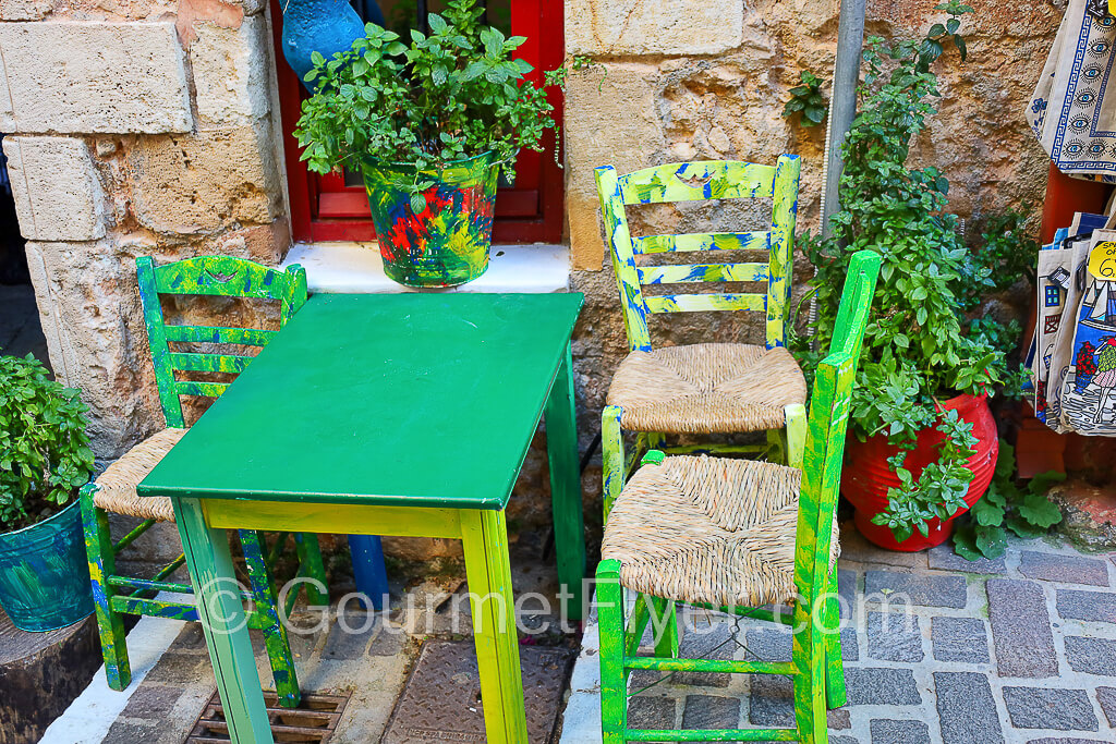 Artsy display of a table with chairs and a vase in vibrant colors.