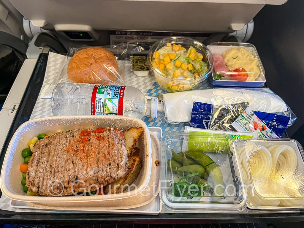 A dinner tray with a plate of hamburger steak accompanied by the side dishes mentioned in the article.