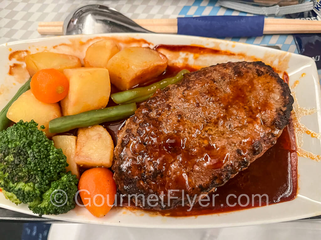 Review of ANA economy class included Paid Exclusive Dining - hamburger steak with fresh vegetables and roasted potatoes.