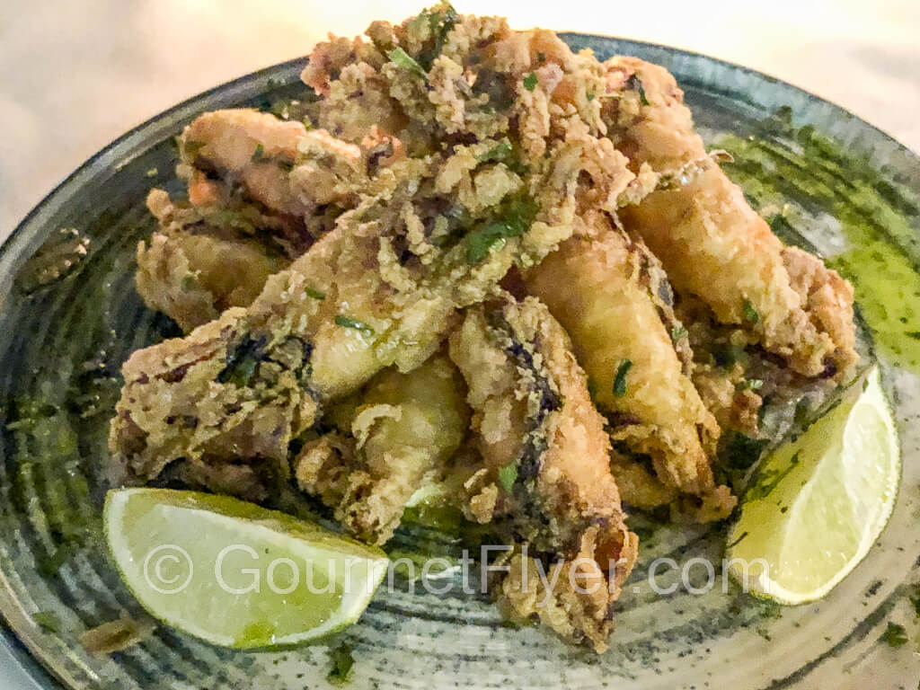 A plate of fried calamari served with garlic lemon olive oil.