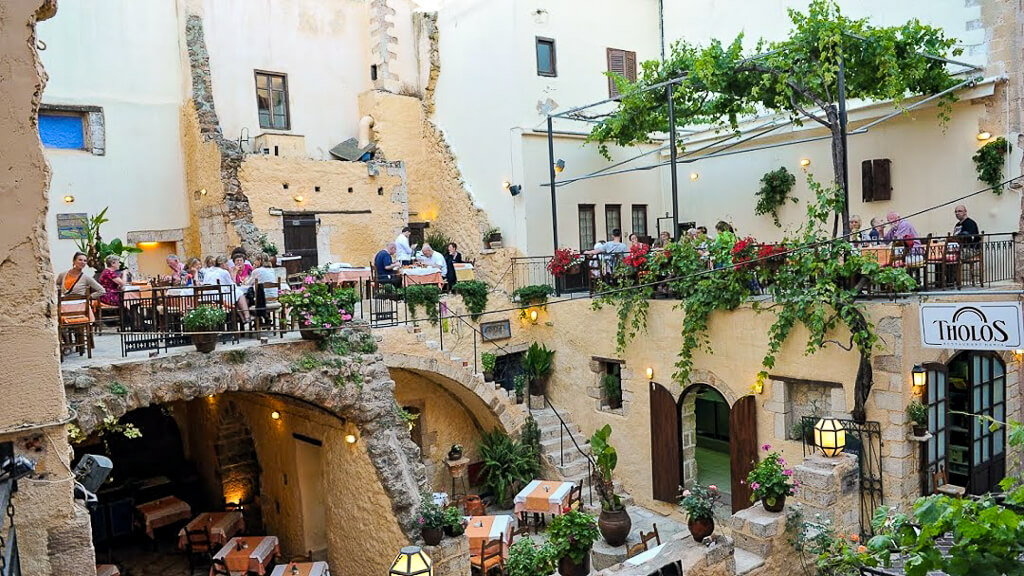 Tables are set up in multiple levels and areas of the remains of an old Venetian building.