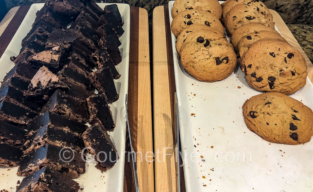 Chocolate brownies on the left and chocolate chip cookies are on the right platter.