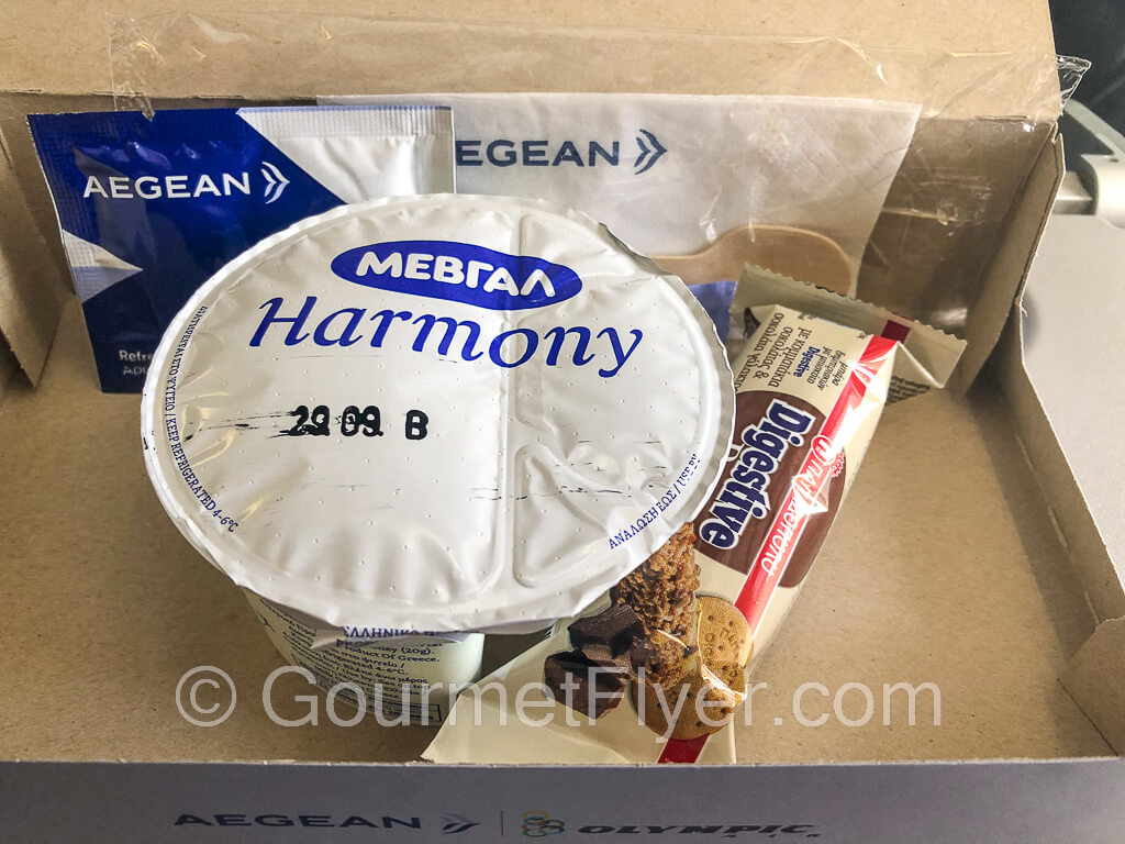 A snack box containing a serving of Greek yogurt and a cereal bar.