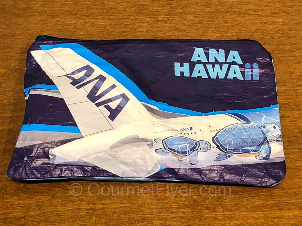 A blue and white pouch with the ANA HAWAII logo and design.