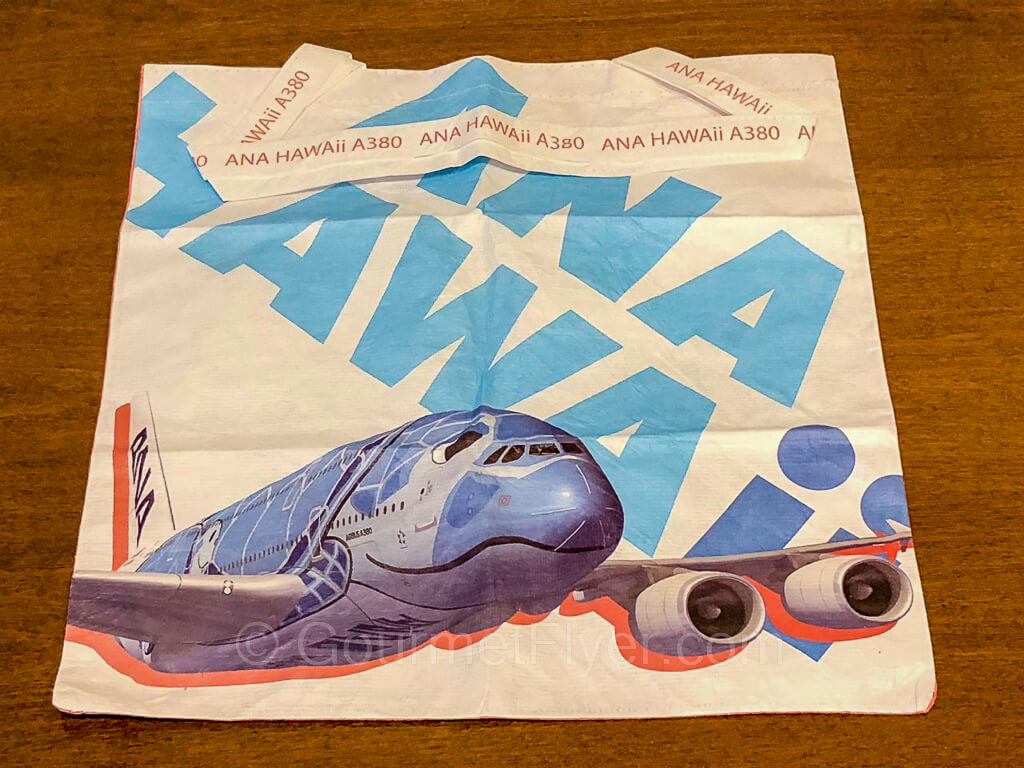 A reusable bag with the ANA HAWAII logo and design and a drawing of an A380 aircraft.
