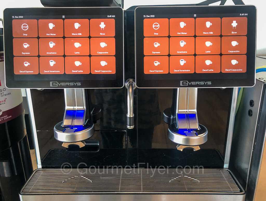 Two espresso machines placed side by side. A on-screen menu is displayed.