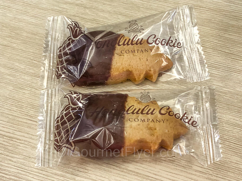 Two chocolate cookies wrapped in plastic are placed on the tray table.