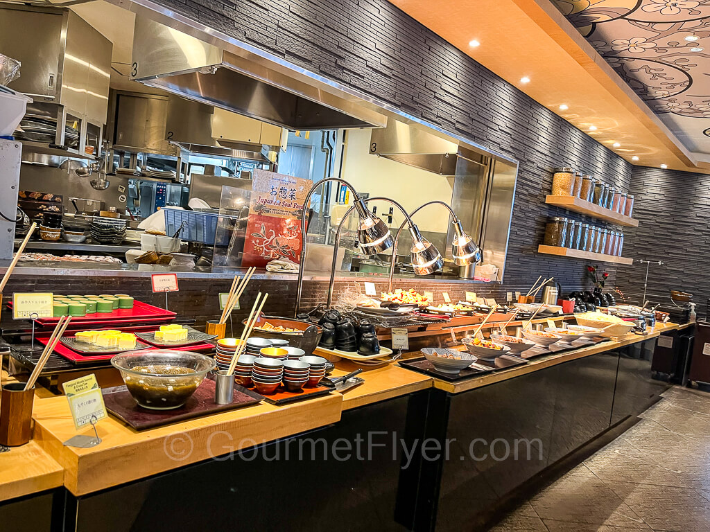 The main buffet counter by the kitchen served mainly traditional Japanese food in bowls and serving dishes with chopsticks.