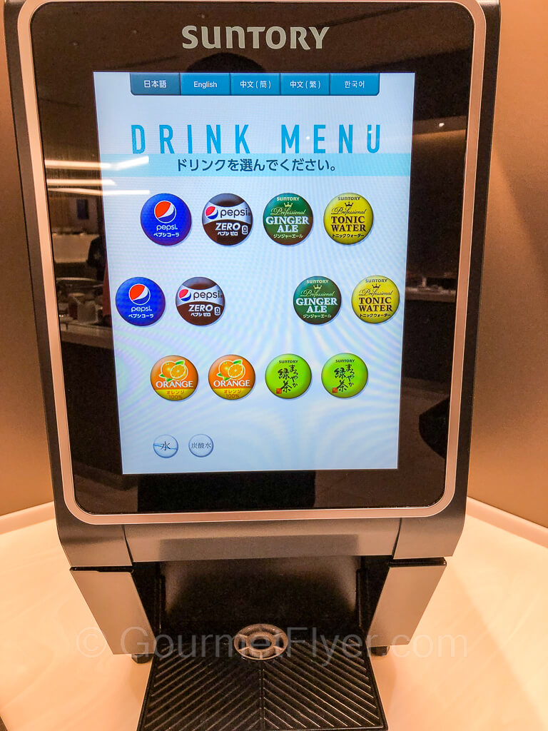 A soda fountain machine with its menu in round colorful buttons on the screen.