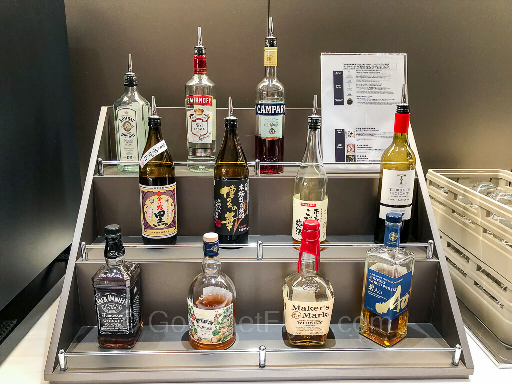 Bottles of liquors, sake, and wine are placed on a 3-tier rack.