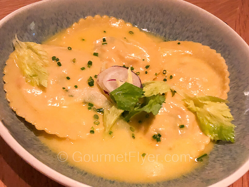 Large raviolis are served with a creamy cheese sauce.