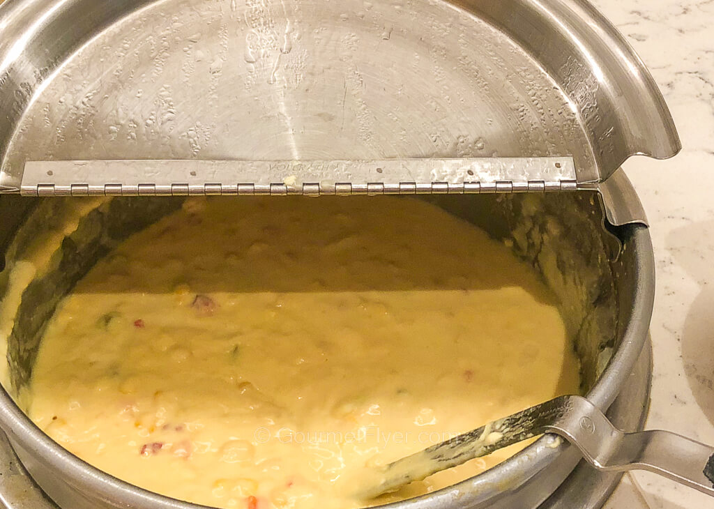 A pot of corn chowder soup is shown with the lid open.