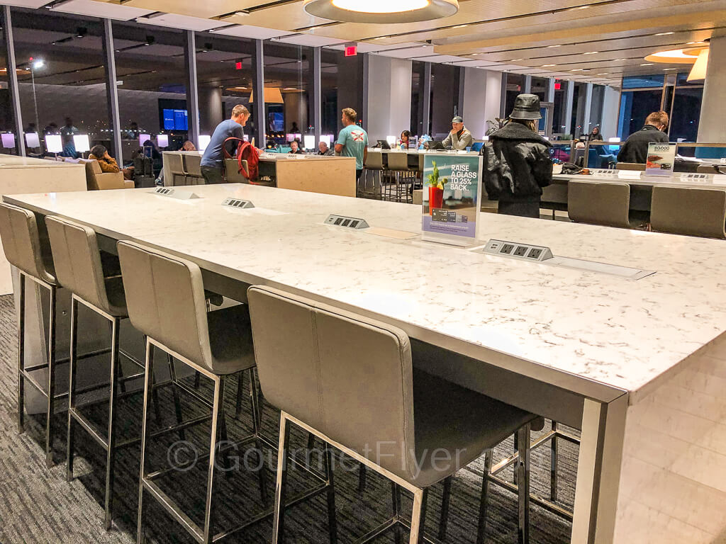 A workstation with highchairs is equipped with power sockets and USB outlets. The plexiglass partitions from the days of COVID 19 have been removed.