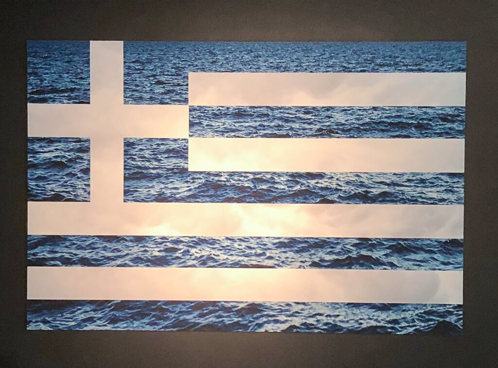 The flag of Greece with the oceans as the blue background is on display.