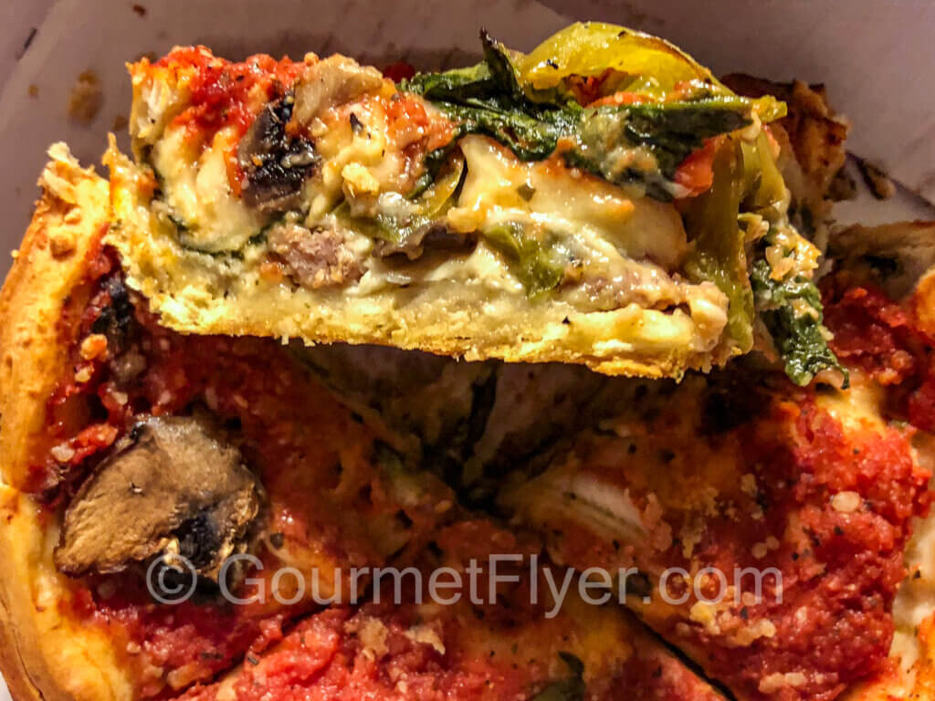 The cross section of a deep-dish pizza shows the layering of its ingredients.