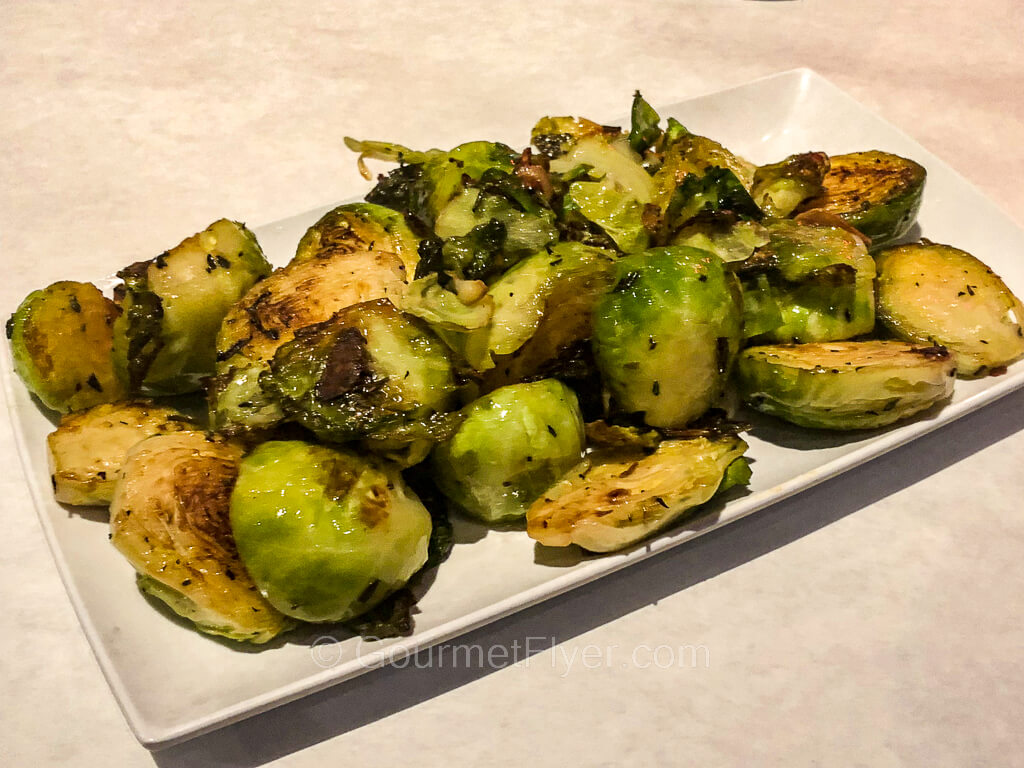 A plate of sauteed Brussel sprouts.