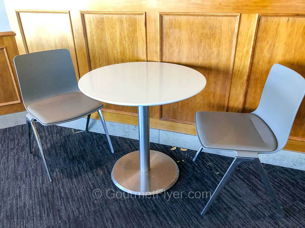 A round dining table is accompanied by two chairs facing each other.