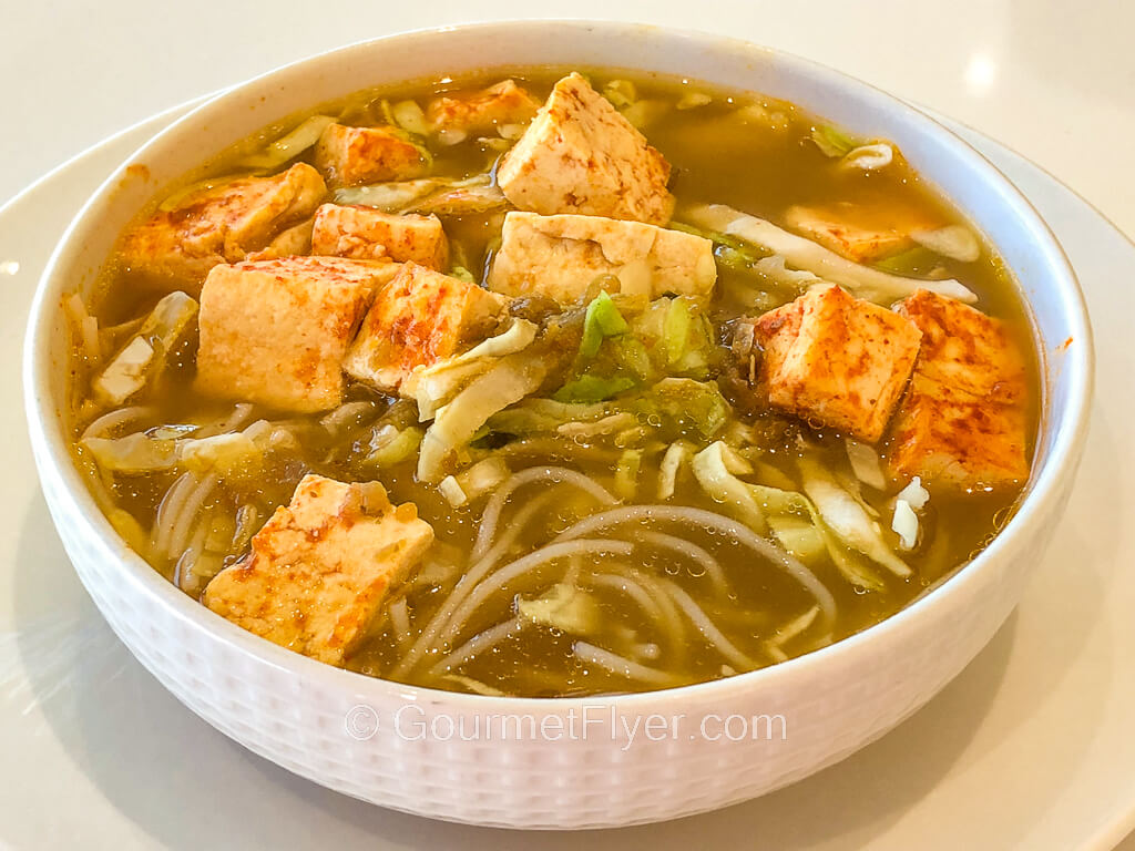 The final product is a bowl of noodles soup with tofu and veggie toppings.