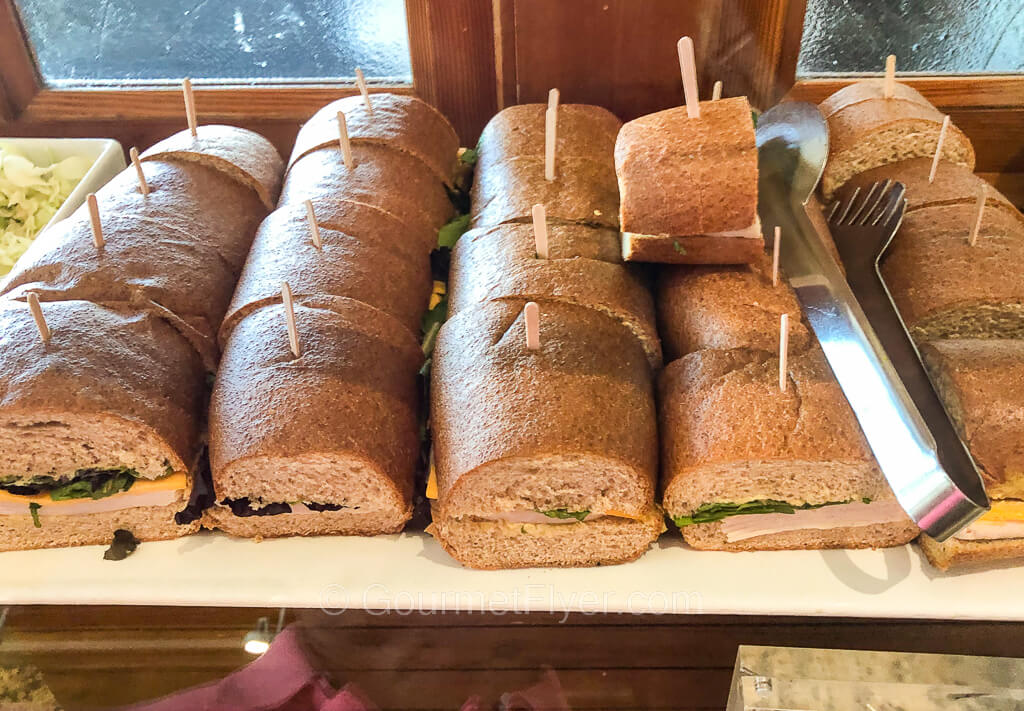 A tray of turkey and cheese sub sandwiches are cut into 2-inch pieces.