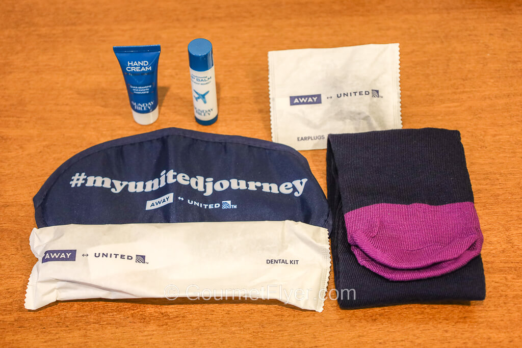 The contents of an amenity kit include eye shades, socks, dental kit, ear plugs, and lotions.