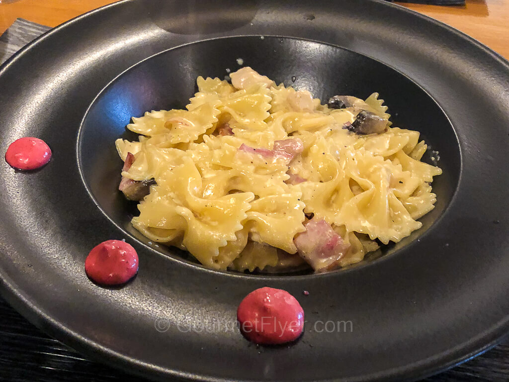 A carbonara dish of bow tie pasta or Farfalle tossed in a cream sauce with bacon.
