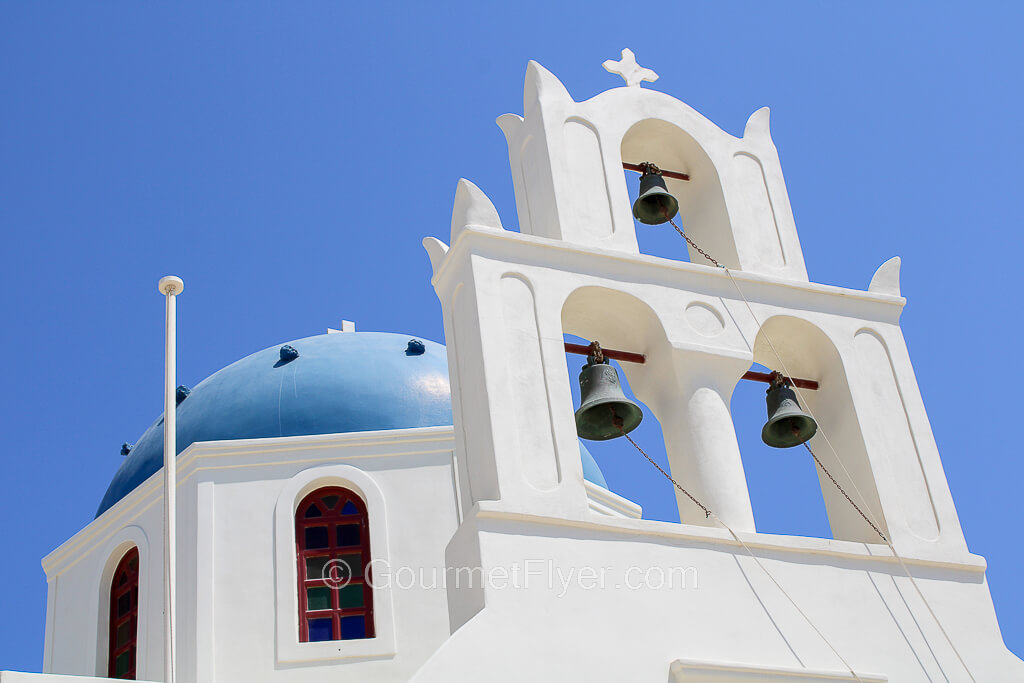 View of the church bells with an iconic blue dome in the background.