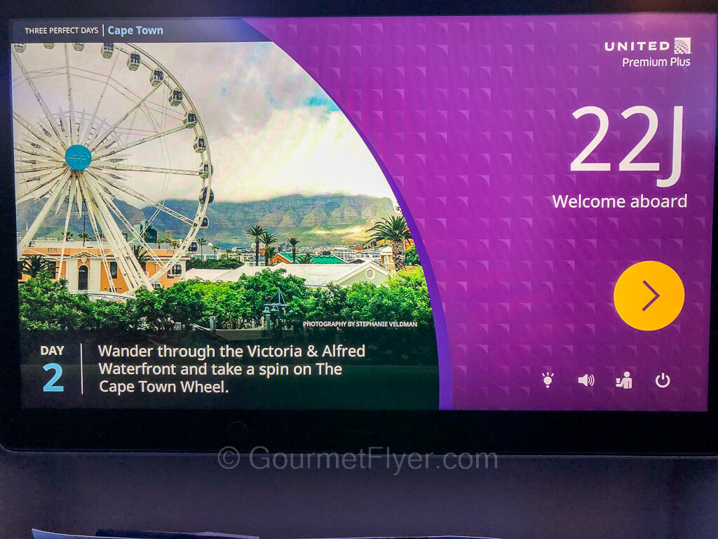 A larger premium economy entertainment screen shows a static picture of a Ferris wheel and seat number 22J.