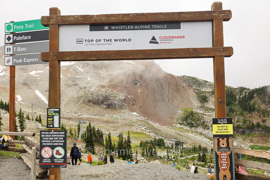 A wooden frame marks an entrance to the trial that leads to the Peak Express Chairlifts.