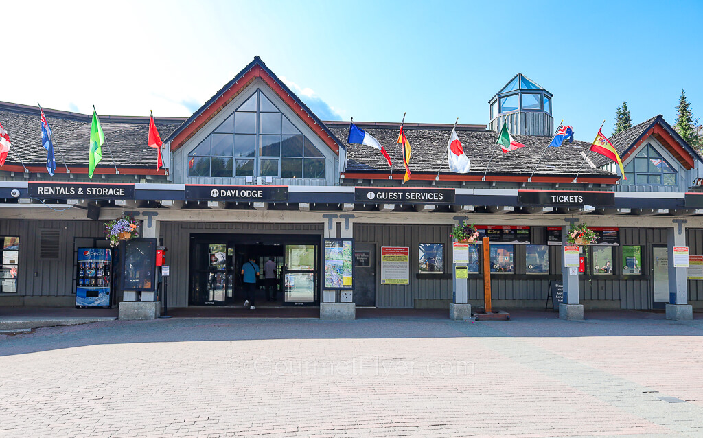 The Daylodge displays the flags of many different countries on its rooftop. There are also signs for tickets and guest services.