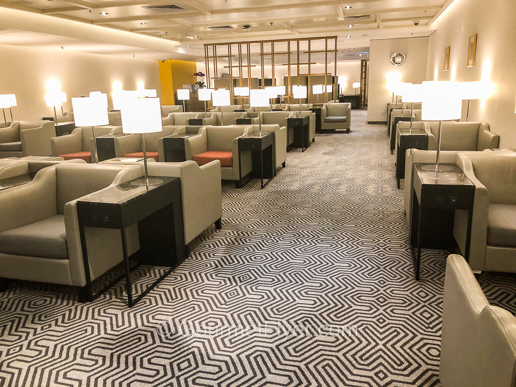 Review of Singapore Airlines' SilverKris Lounge in HKG features an area with wide and comfy sofas accompanied by elegant coffee tables and lamps.