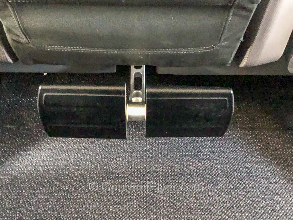 A footrest mounted to the seat in front is a few inches on top of the carpet on the floor.