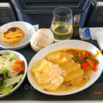 Review of Air Canada's Premium Economy class features a dinner tray with chicken and potatoes, salad, and dessert.