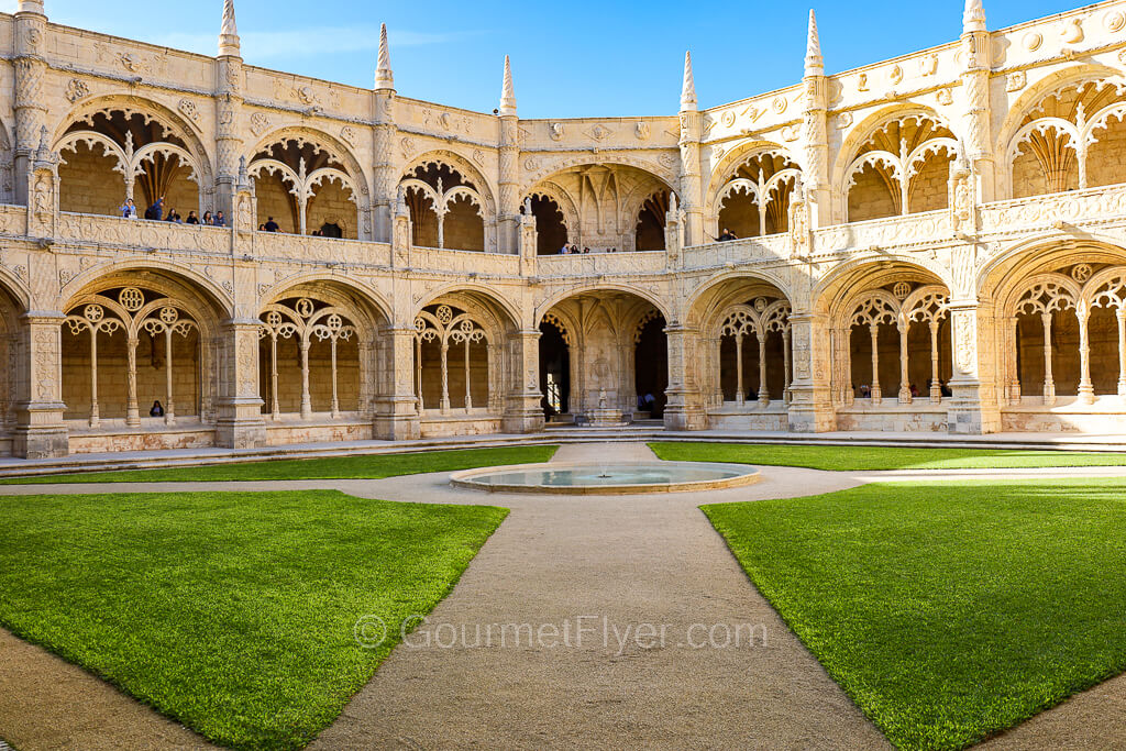 The two stories of the cloister of the Jeronimos Monastery surrounds a courtyard in the center.