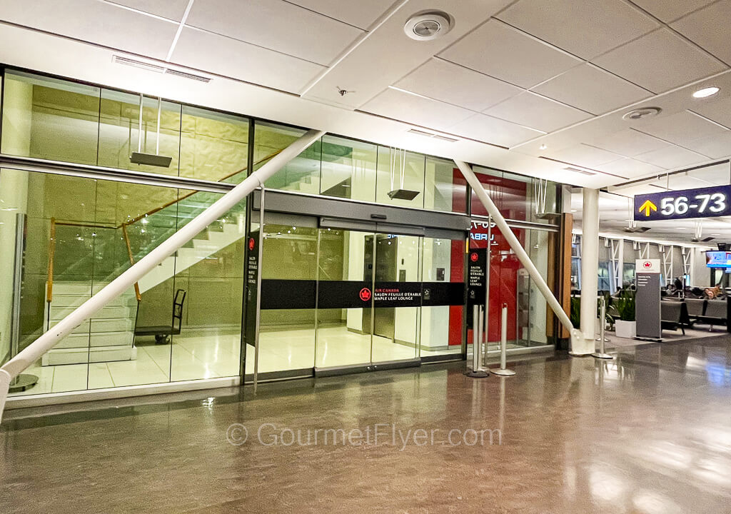 The entrance to Air Canada's Maple Leaf Lounge features large glass panels and a sliding glass door.