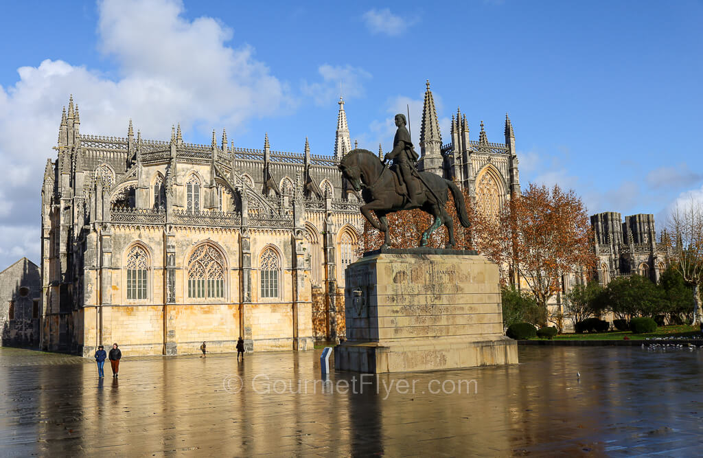 A bronze statue of a general on his horseback sits in front of a majestic Gothic church.