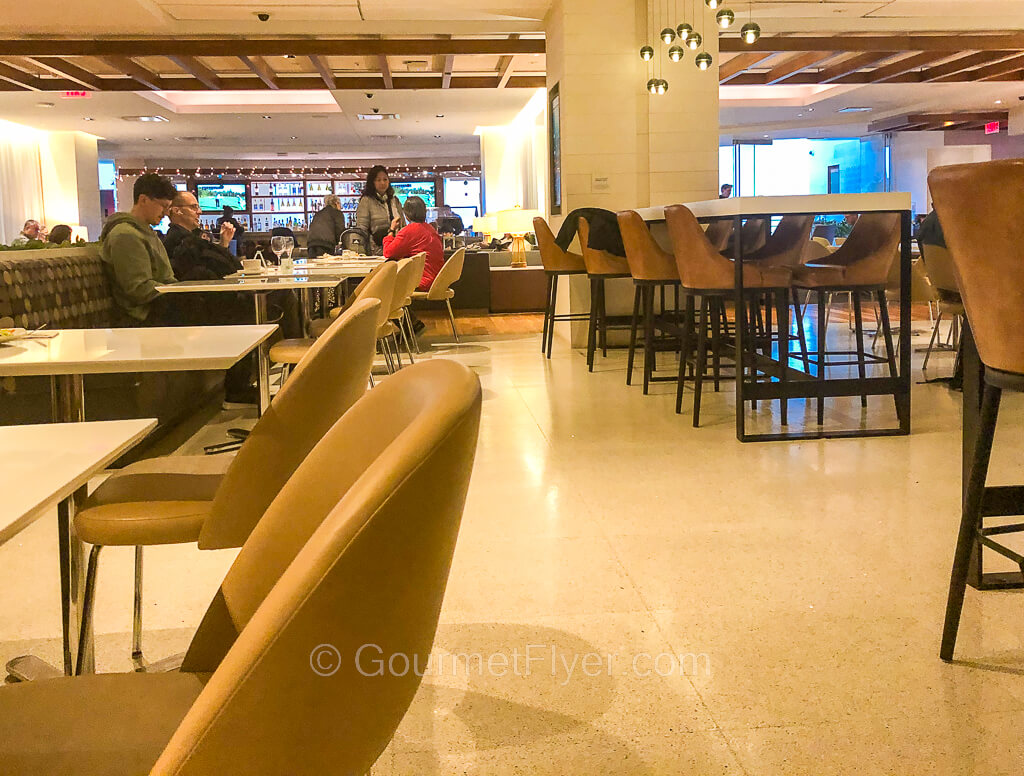 To the left of a dining area are booth chairs while a high top occupies the right side of the space.